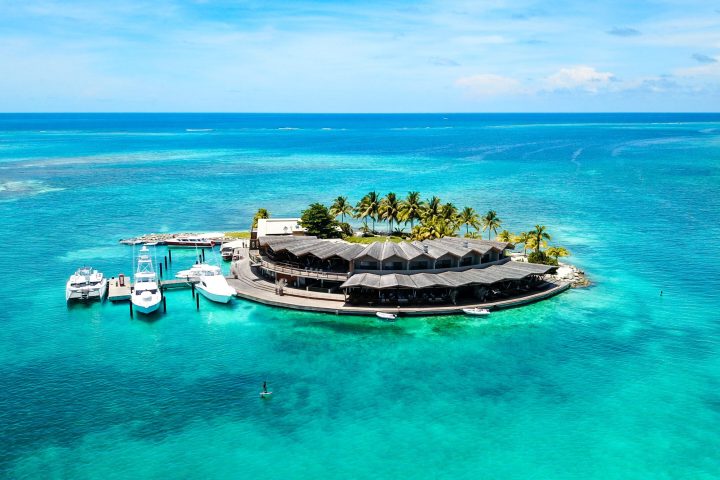 a blue and white boat sitting next to a body of water